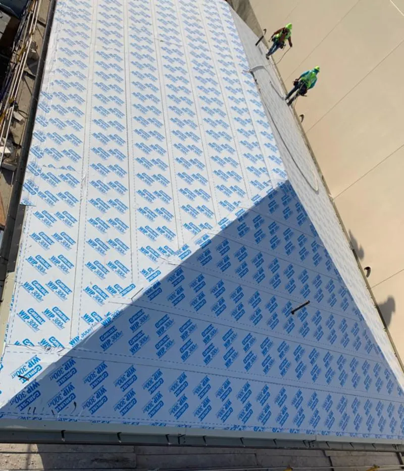 Professional roofers installing underlayment on a metal roof in Todd Creek